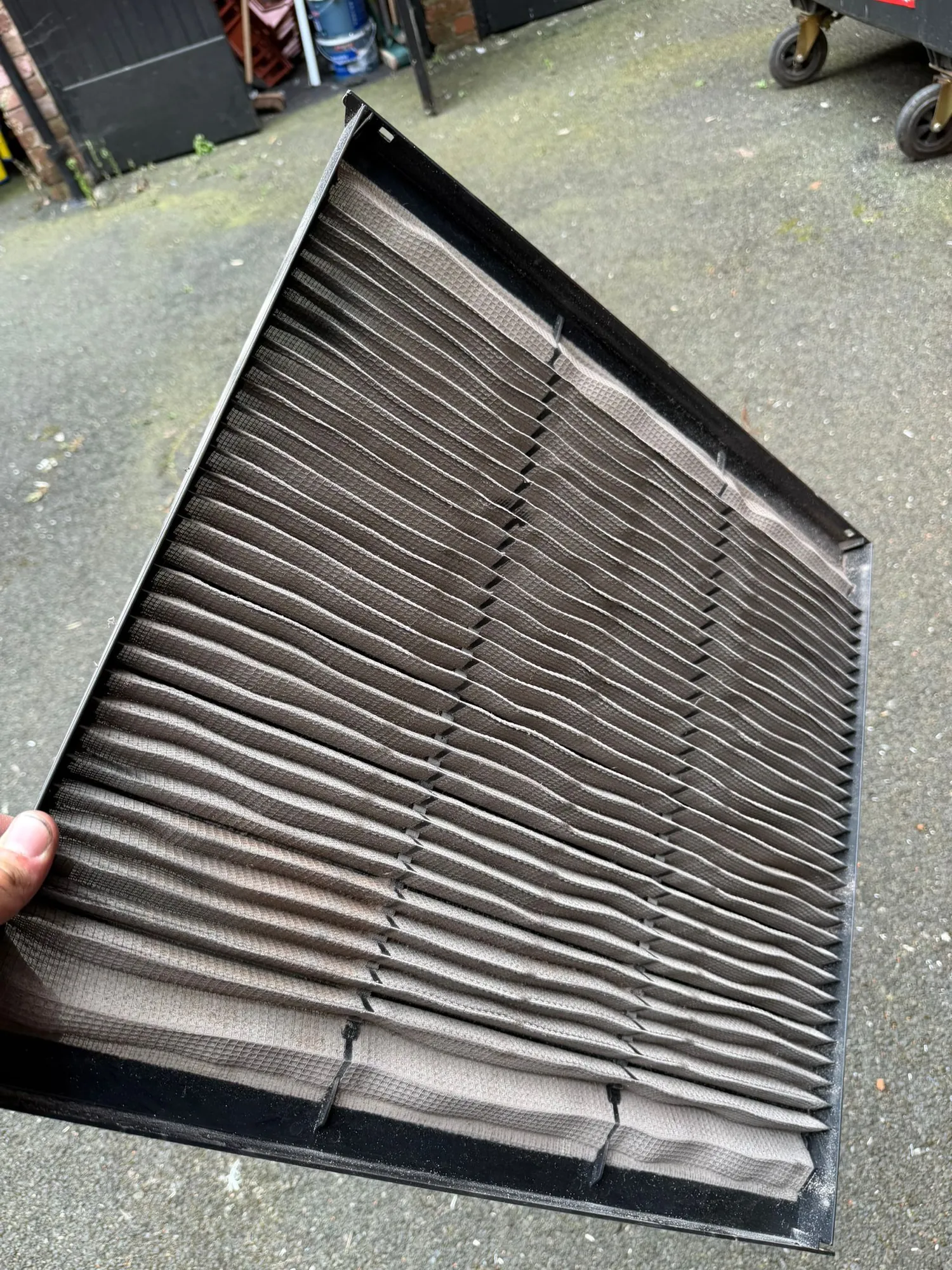 Dirty clogged air conditioning filter removed for cleaning during an Aervue service